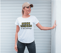 a woman is leaning against a wall wearing a white t - shirt